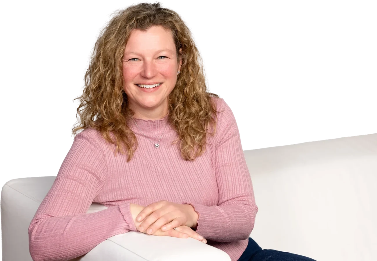 Natasha Lachapelle, coach de vie à Chambly, souriante, assise sur un sofa blanc